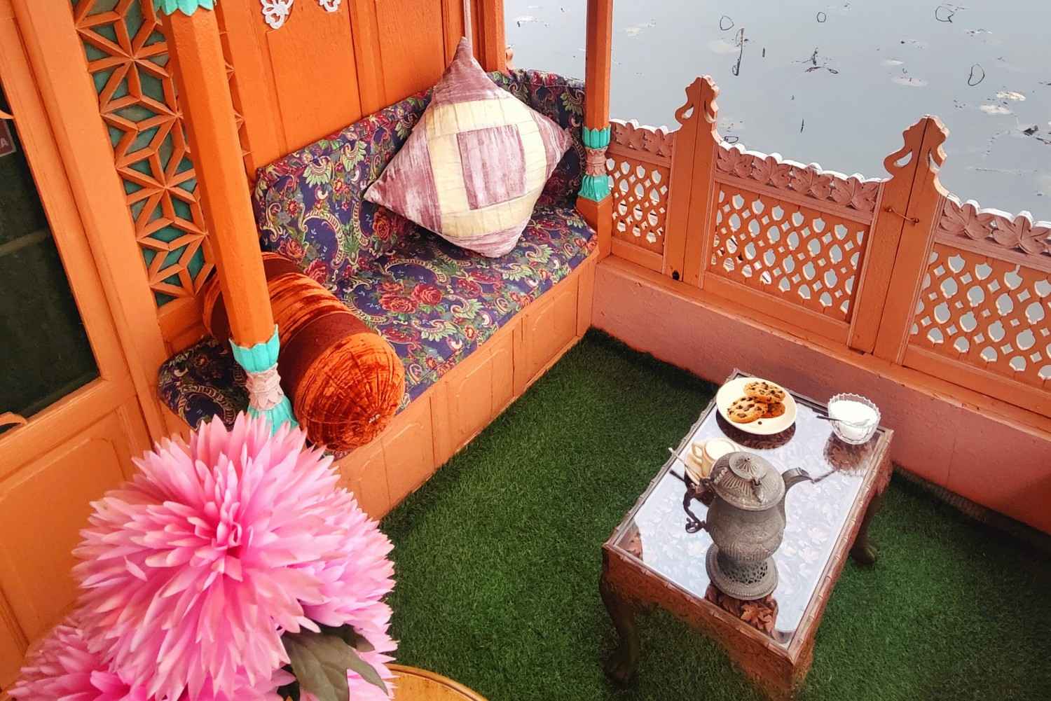 Luxury houseboat balcony seating on Dal Lake Srinagar with traditional Kashmiri decor and tea setup