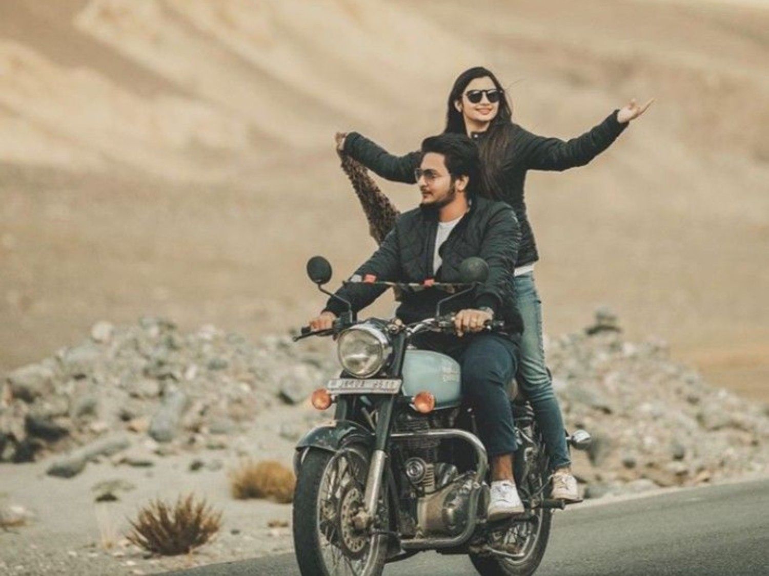 Couple enjoying an adventurous pre wedding photoshoot on a bike in Kashmir’s scenic landscape