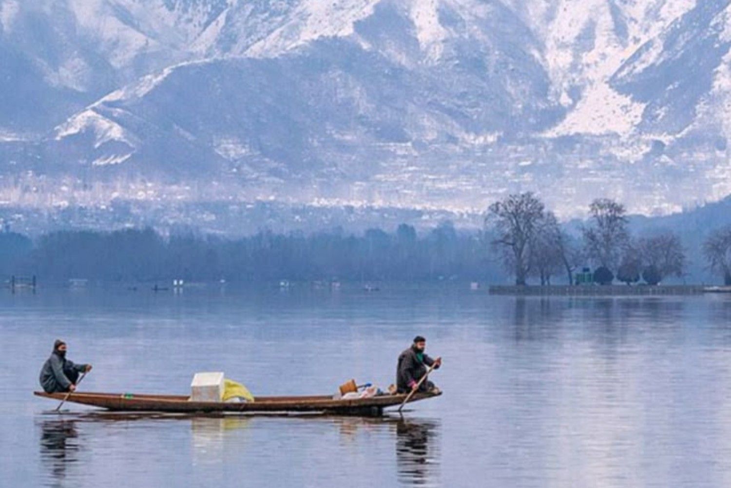 Shikara ride on Dal Lake Srinagar with snow mountains in Kashmir