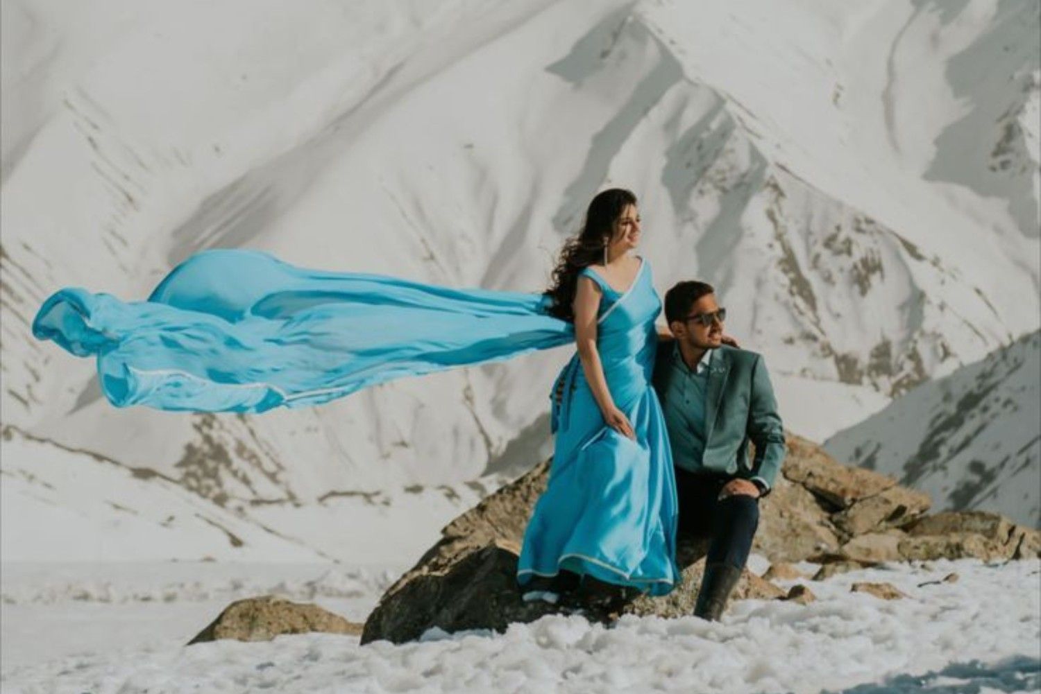 Snow pre wedding photoshoot in Kashmir with a couple posing against snowy mountains