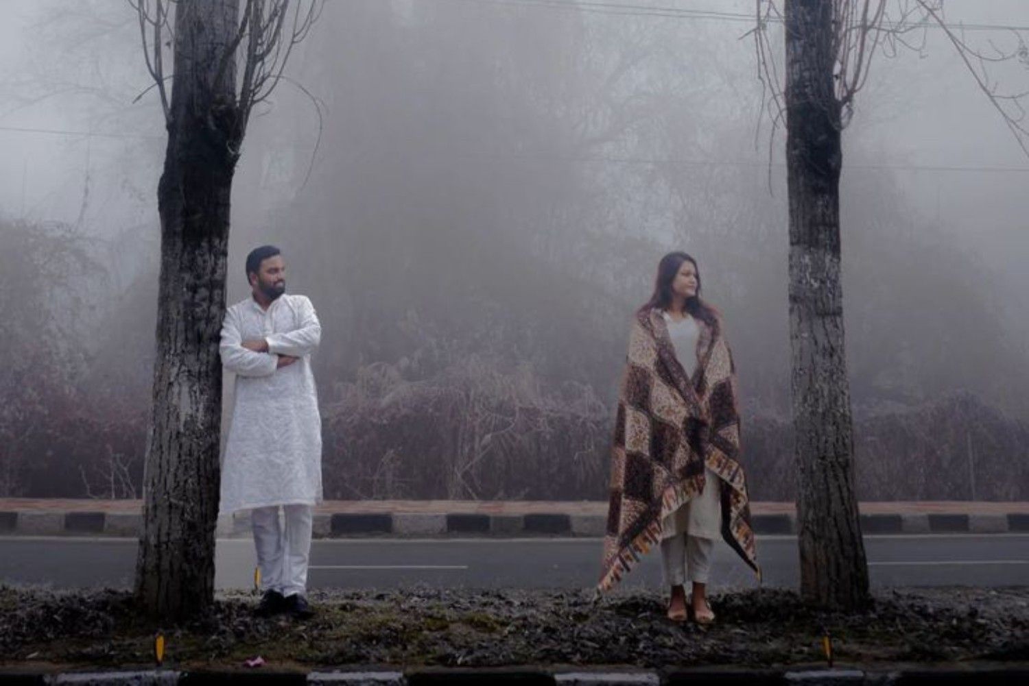 Traditional pre wedding photoshoot in Kashmir with a couple in ethnic attire during winter fog